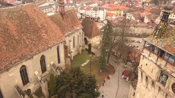 A drone shot, with forward motion, capturing a glimpse of the city of Sighisoara on an afternoon