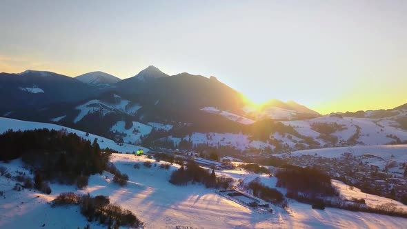 Aerial Colorful Winter Sunset over Rural Countryside in Snowy Alpine Nature Landscape