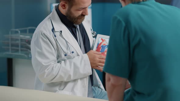 General Practitioner Holding Tablet with Heart Condition