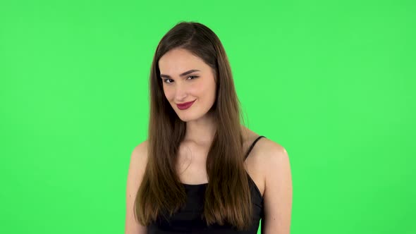 Lovely Girl Smiles Broadly and Winks Flirting. Green Screen