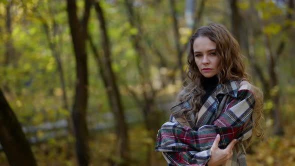 Lonely and Scared Lady is Standing Alone in Forest in Autumn Day