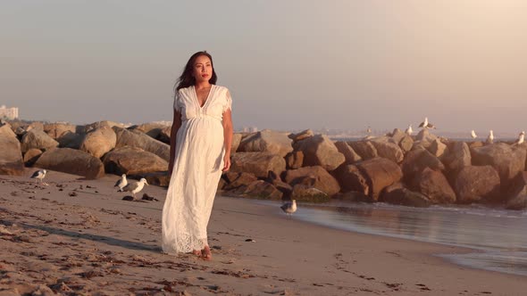 Pregnant Asian woman enjoying walk on the beach