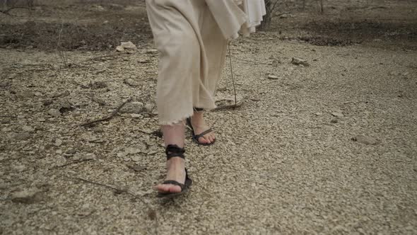 The Feet Of Jesus Christ Wearing A White Robe Walking In Slow Motion