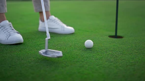 Golfer Legs Hitting Ball on Green Golf Course