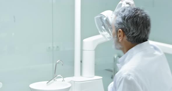 Dentist Turning on Lamp Before Examination