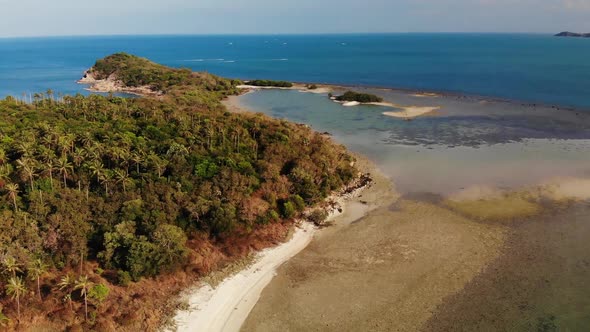 Small Island and Coral Reef in Ocean. Drone View of Green Uninhabited Island and Amazing Coral Reef