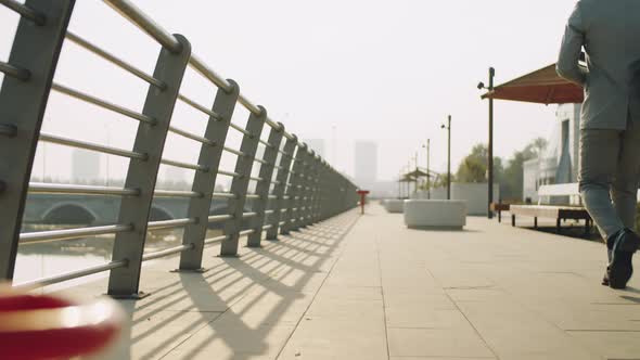 Businessman Walking on Embankment in City