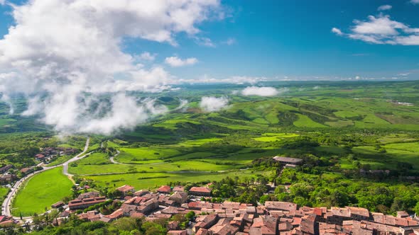 Time lapse aerial: unique green landscape in Orcia Valley, Tuscany, Italy. Scenic clouds moving by w