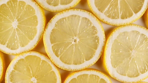 Slow Motion of Fresh Lemons Slices on Yellow Background