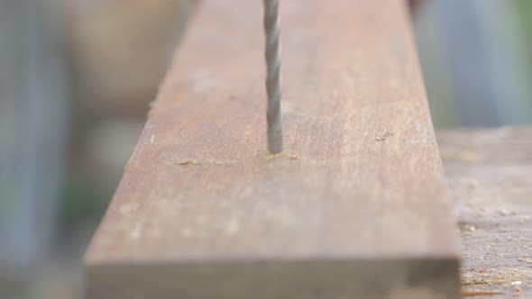Drilling hole through dry wooden board 4K 2160p UHD footage - Hole in dry wooden board shallow DOF 4