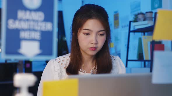 Asia women using laptop hard Working from house overload at night, remotely work, self isolation