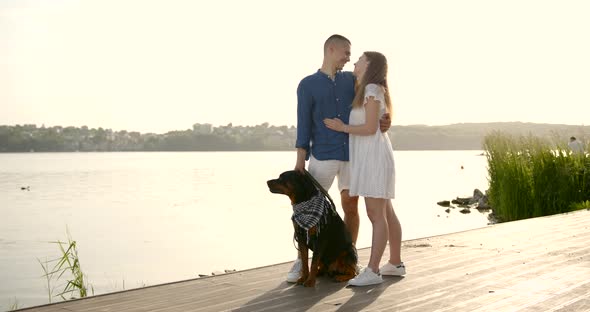 Loving Young Couple with a Dog By Lake