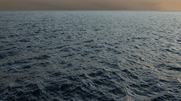 Flight over the waves of the ocean to the endless horizon. Aerial View of Sea Horizon.