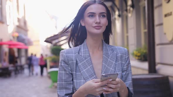 Beautiful Smiling Woman Using Phone Walking On City Street