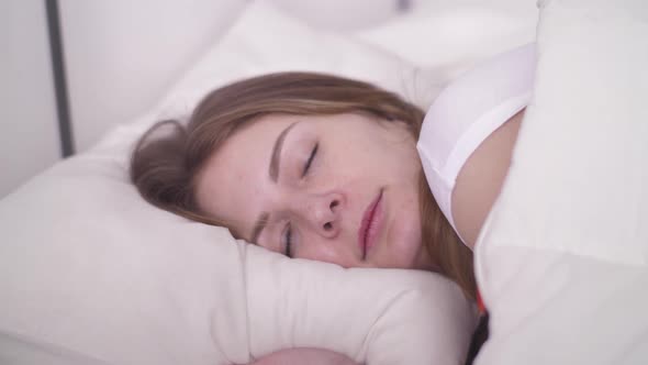 Young Woman Sleeping Well in Cozy Bed on White Pillow Linen, Healthy Deep Sleep