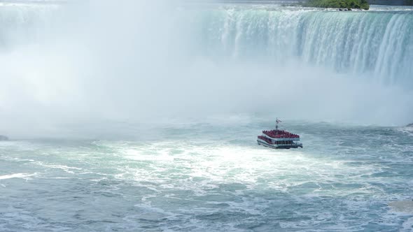 Tourism tour ferry approaching the waterfall rapids of Niagara Falls