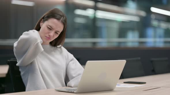 Woman having Neck Pain while Typing on Laptop