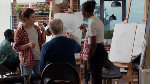 Diverse Team of Women Giving Drawing Lesson to Elder Person