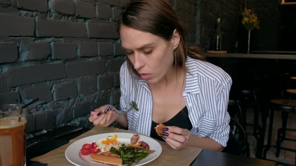 Beautiful Woman Having Breakfast in a Restaurant