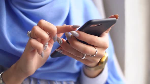 Close-up of Luxurious Hands of Young Muslim Woman Using Smartphone. Slow Motion