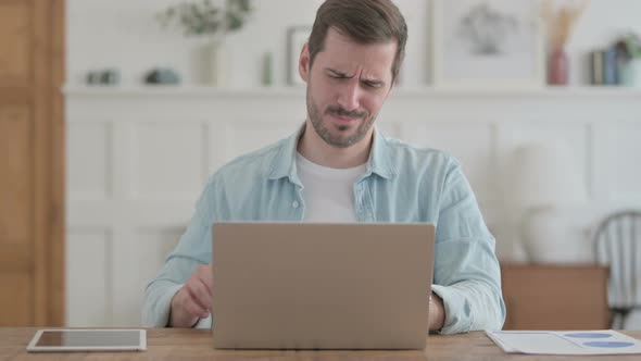 Young Man Having Back Pain While Using Laptop