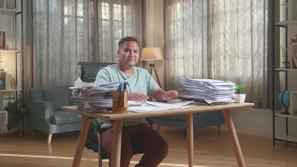 Fat Asian Man Crossing Arms And Smiling To Camera While Working With Documents At The Office