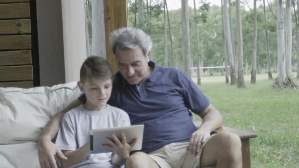 Father and son looking at digital tablet together