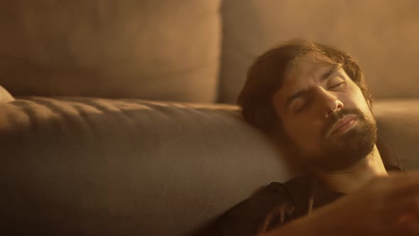 Man Playing on Guitar While Sitting on the Floor with Closed Eyes