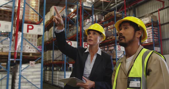 Female warehouse manager and male warehouse worker talking 4k