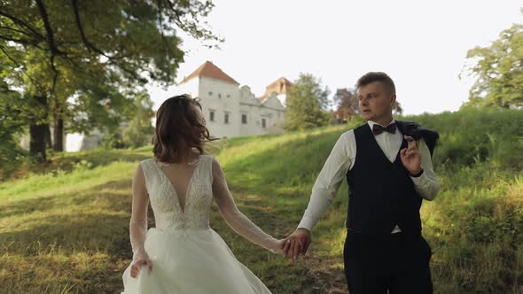 Groom with Bride Walking in the Park. Wedding Couple. Happy Family. Newlyweds