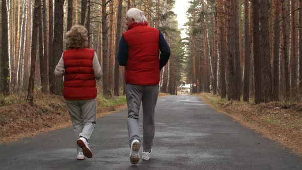 Active Elderly Man and Woman Running Outdoors