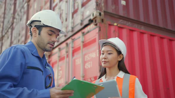 Two engineer male and female worker dockers in checking examine discussion