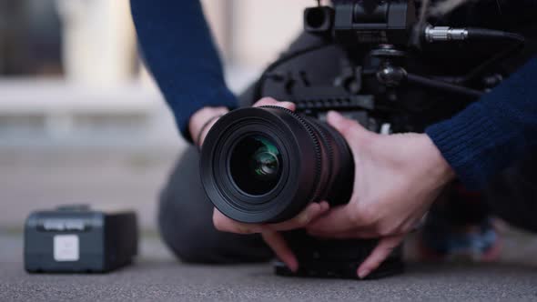 Female Film Maker Fitting Lens Onto Camera