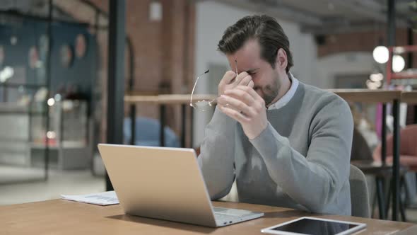 Young Man Having Headache While Working on Laptop