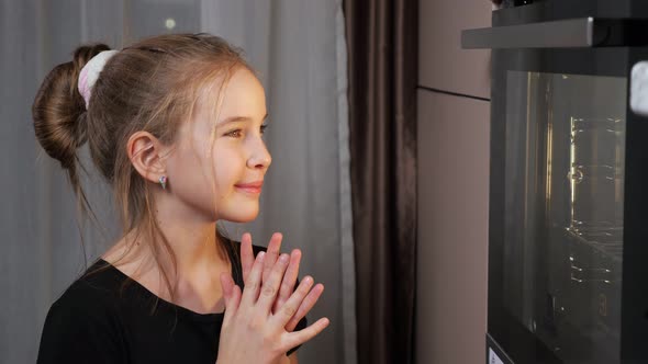 Teenager Girl Waits for Food Preparing in Stove at Home