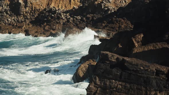 Huge waves splashing against cliffs.