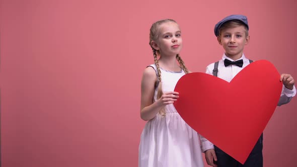 Kids Couple Holding Red Heart Cutout and Smiling, Valentines Day, Love Concept