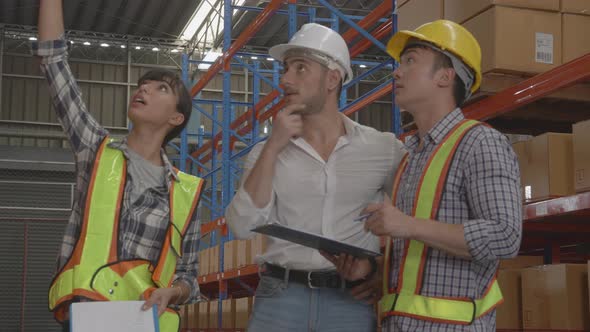 Group team engineer while manager talking with worker and looking document on clipboard.