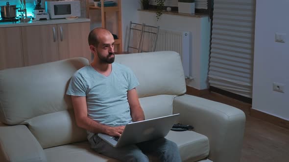 Caucasian Male Sitting in Front of Television While Working at Communication Project