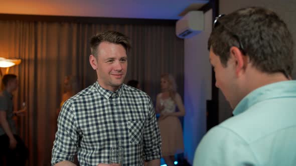 Young Handsome Guy Talking with His Friend at Private Party