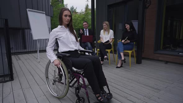 Sad Disabled Woman in Wheelchair Rolling Away As Colleagues Laughing Mocking at Background