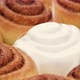 pouring fluffy frosting on Freshly baked cinnamon rolls or Cinnabon close up. - VideoHive Item for Sale