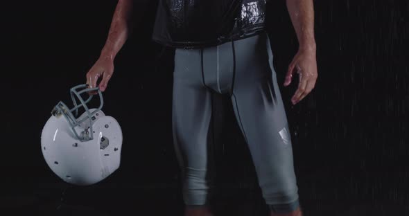 Portrait of the Determined Professional American Football Player in Dark Night Holding the Ball