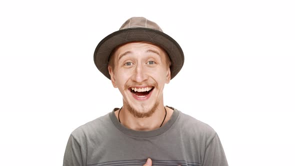 Surprised Young Handsome Man in Hat Smiling Rejoicing Over White Background