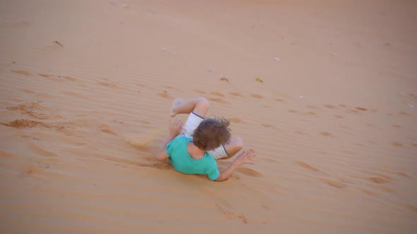 Slowmotion Shot of a Little Boy is Having Fun in a Desert