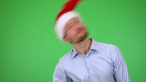 A Young Handsome Man Spins His Christmas Hat, Then Smiles at the Camera - Green Screen Studio