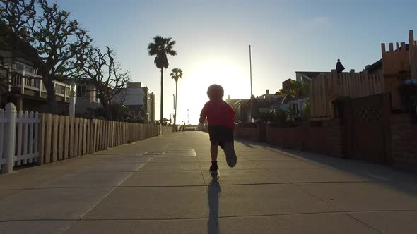 A boy rides a scooter in a neighborhood.