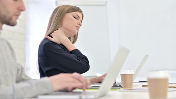 Creative Woman Working on Laptop and Having Neck Pain in Office