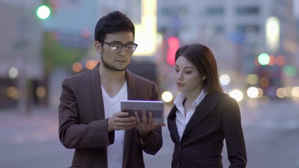 Two Business People Looking at Tablet Screen Together alt