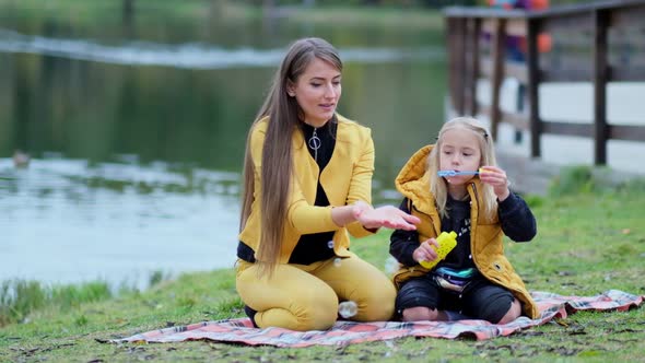Mother and Daughter Inflate Soap Bubbles